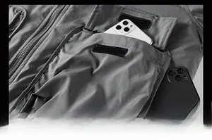Detail of multi-pocket bomber jacket showing large cargo pockets with dual smartphones inside