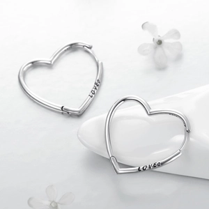 S925 sterling silver heart-shaped hoop earrings featuring LOVED engraving on a white surface