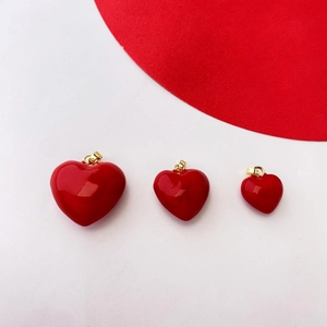 Three red heart pendants in various sizes with polished finish and gold bail connectors