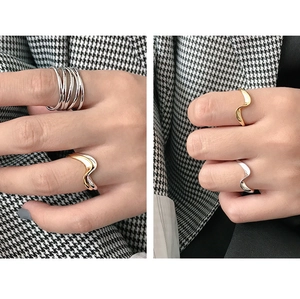 Detailed view of wavy S925 sterling silver rings in gold and silver on a model