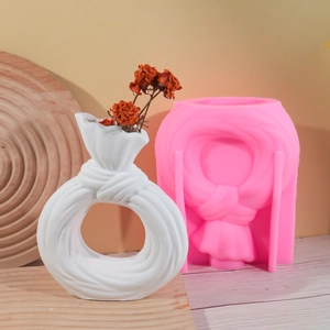 Detalle del molde de silicona rosa y jarrón blanco plisado circular para decoración DIY