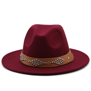 Close-up of brown leather band with silver studs on burgundy wool fedora hat