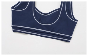 Detail of navy yoga sports bra featuring white contrast stitching and U-neckline