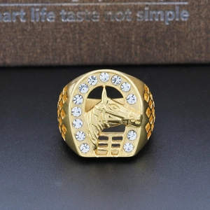 Macro shot of gold horse head ring with sparkling crystals on horseshoe frame