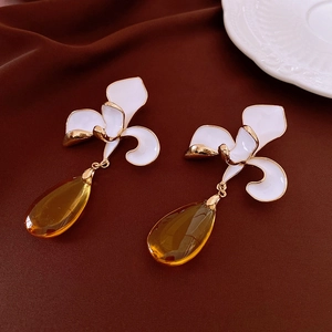 Detail of vintage flower stud earrings with amber teardrop pendants on velvet background