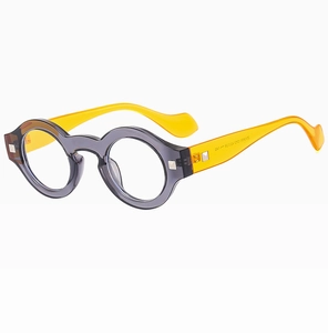 Close-up of vintage round glasses frame with gray front and bright yellow temples