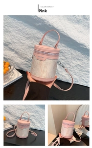 Detail of pink embroidered bucket bag with structured top handle and adjustable strap