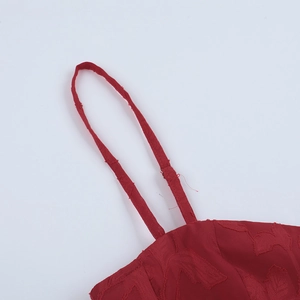 Detailed macro view of red leaf jacquard fabric texture and slim shoulder straps