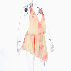 Close-up of deep V-neckline and orange floral print on a lightweight halter maxi dress