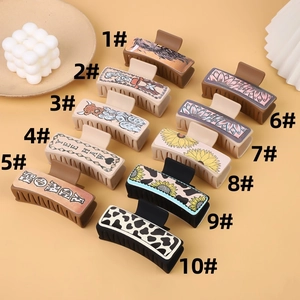 Detailed flat lay of ten Western-style hair claw clips with various desert patterns