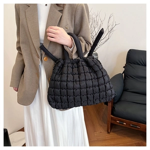 Lifestyle shot of large black quilted puffer tote bag with stylish drawstring handles