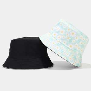 Detail view of cotton bucket hats in solid black and floral mint green prints