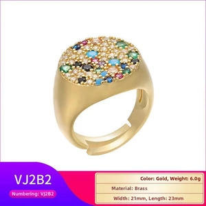 Makro-Detail des goldenen offenen Rings mit bunten Zirkonia-Steinen und Messing-Textur