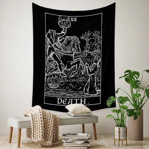 Detail of bohemian black and white tarot death tapestry hanging on a white bedroom wall
