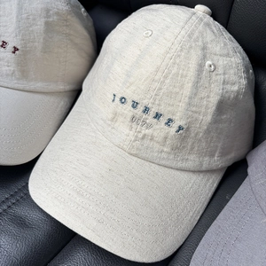 Dettaglio della trama in cotone del cappello con ricamo Journey 007 sul davanti