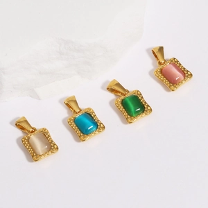 Detail of four colorful square cubic zirconia pendants in gold settings on white rock