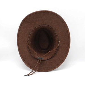 Dettaglio di un cappello da cowboy marrone con tesa larga e cinturino antivento intrecciato
