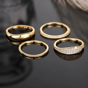 Macro shot of gold-plated stacking rings set with sparkling cubic zirconia on black background