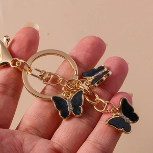 Detailed shot of black enamel butterfly keychain with gold plating and sparkling crystals