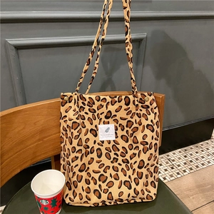 Detailed texture of leopard print corduroy tote bag featuring an artistic snap button design