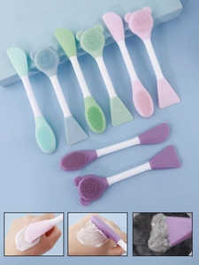 Close-up of double-headed silicone facial brush showing soft bristles and flat spatula tip