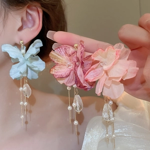 Macro detail of fabric flower earrings with crystal drops and pearl tassels on silver needles
