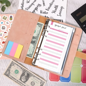 Flat lay of pink A6 PU leather budget binder with 6-ring clips and expense tracking sheets