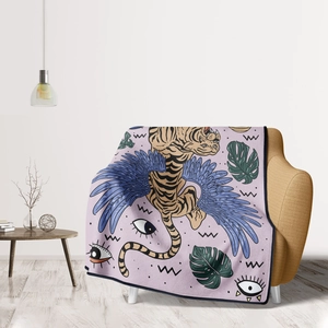 Detail of soft flannel blanket with tiger and blue wings draped over yellow sofa