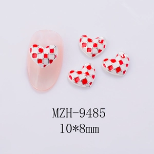 Macro detail of red and white checkerboard heart nail art charms with silver alloy borders