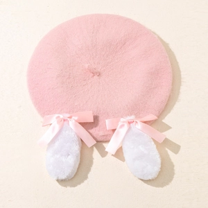 Détail du béret en tricot rose orné d'oreilles de lapin blanches et de nœuds en satin