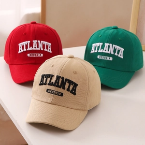 Close-up of three cotton baseball caps in red, green, and beige with Atlanta embroidery