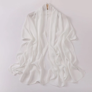 Detail showing the elegant drape of white translucent chiffon shawl on wooden hanger