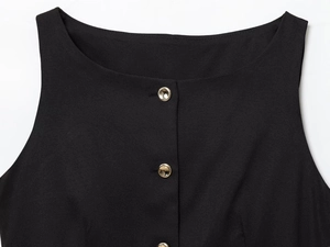 Close-up of black sleeveless top with round neck and decorative gold metal buttons