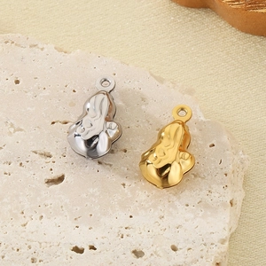 Close-up of gold and silver irregular molten metal pendants on a textured stone surface