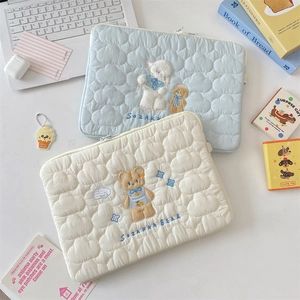 Detalle de las fundas acolchadas para portátil con bordado de oveja y osito
