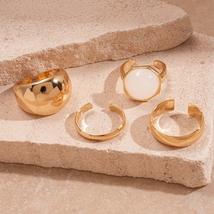 Set of four gold geometric resin rings featuring oval dome and round stone designs