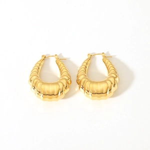 Gros plan de boucles d'oreilles en U plaquées or 18 carats avec texture nervurée
