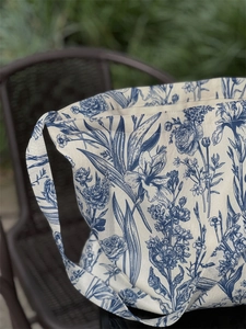 Detail view of the vintage blue floral pattern and texture on a canvas tote bag