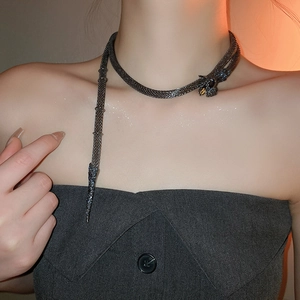 Detailed view of snake-shaped choker with gemstones and flexible mesh texture