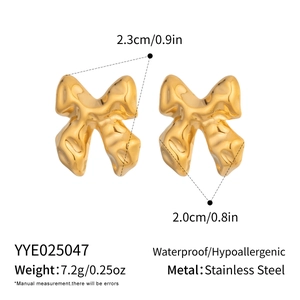 Detail of golden bow earrings with liquid metal texture, waterproof and hypoallergenic