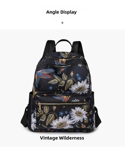 Front angle view of a black backpack with vintage hummingbird and floral patterns