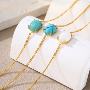 Detailed view of three 18k gold necklaces featuring oval turquoise and marble stone pendants
