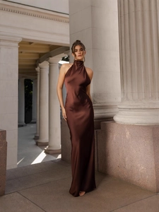 Elegant chocolate brown satin maxi dress with halter neck design on model in classic setting