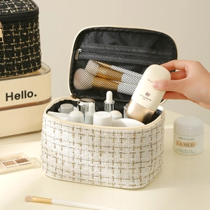 Beige tweed makeup bag with LED mirror showing internal storage capacity and gold thread
