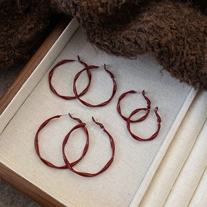 Three pairs of vintage dark red twisted earrings in large, medium, and small sizes