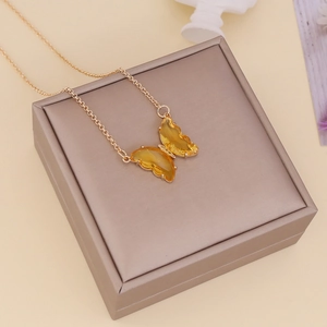 Detailed shot of yellow crystal butterfly pendant on a gold necklace in a jewelry box