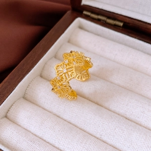 Close-up of vintage gold open ring with hollow lace texture and tiny zircon inlay