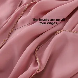 Detail of pink chiffon scarf featuring gold beaded edges decorated along all four sides