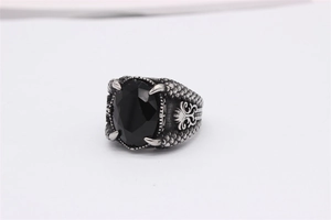 Detailansicht eines gotischen Drachenkrallenrings mit großem schwarzem Stein und Schuppen