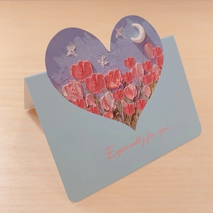 Detail of 3D oil painting heart card showing pink tulips and moon on light wood background